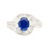 Natural 1.14 Carat Oval Cut Blue Sapphire with Round & Baguette Cut Diamonds in a Swirled 18K White Gold Ring Setting